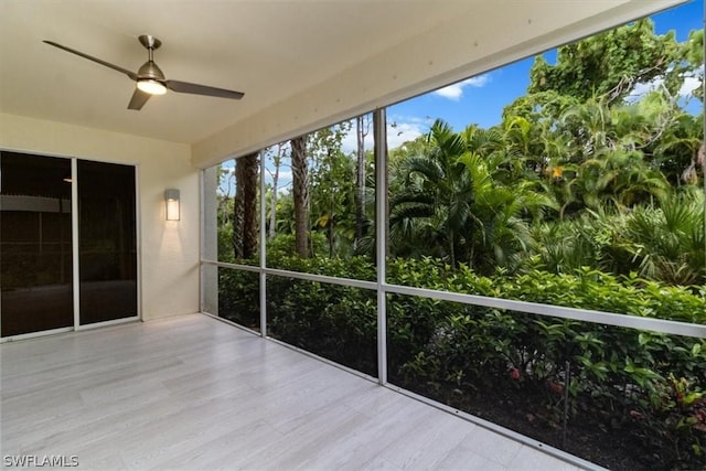 unfurnished sunroom featuring ceiling fan