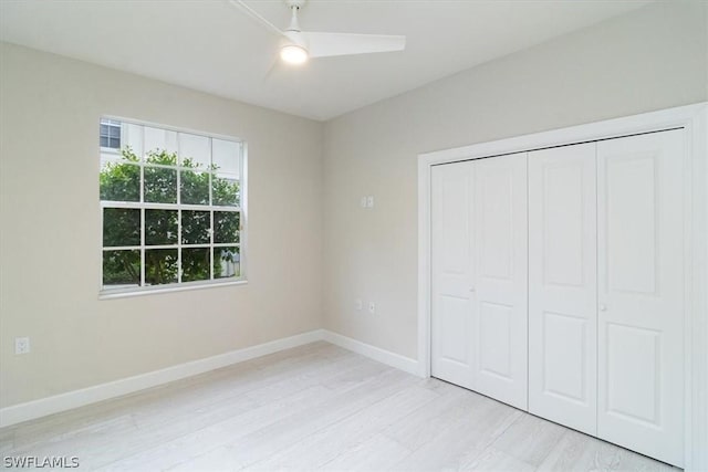 unfurnished bedroom featuring ceiling fan, a closet, and light hardwood / wood-style flooring