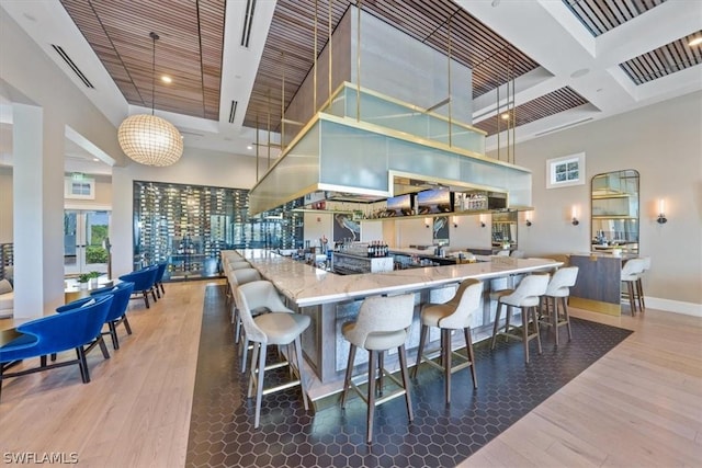 kitchen with hardwood / wood-style flooring, a high ceiling, and pendant lighting