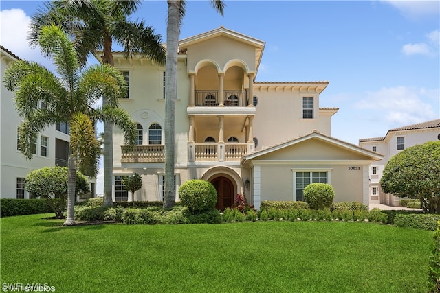 mediterranean / spanish-style house with a front yard and a balcony