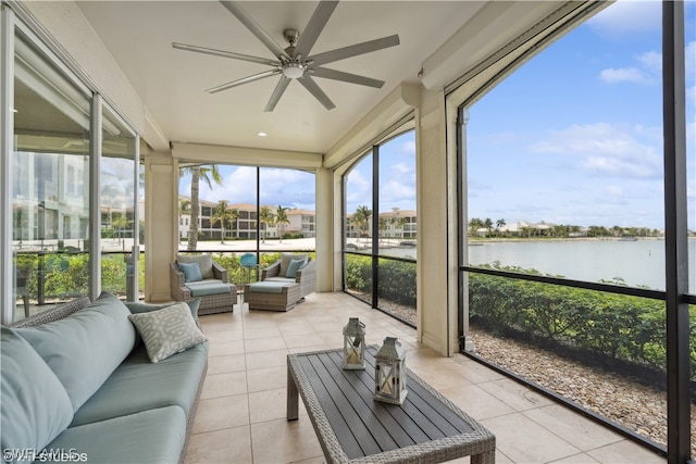 sunroom / solarium with ceiling fan and a water view