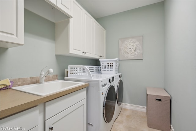 washroom featuring sink, separate washer and dryer, cabinets, and light tile floors