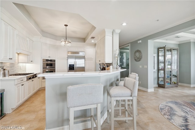 kitchen featuring a tray ceiling, kitchen peninsula, tasteful backsplash, a kitchen bar, and appliances with stainless steel finishes