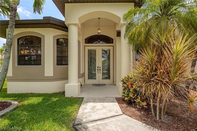 doorway to property featuring french doors and a lawn