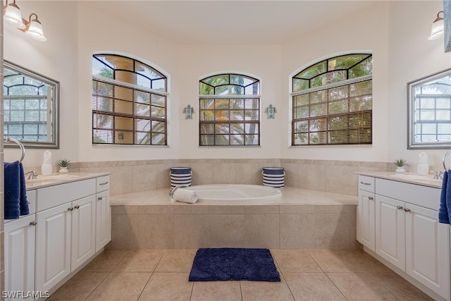 bathroom with a relaxing tiled bath, tile flooring, and vanity