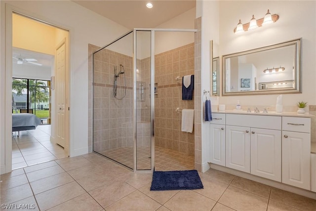 bathroom featuring tile patterned flooring, vanity, and tiled shower