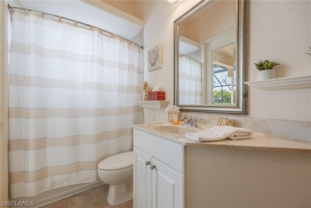 bathroom with vanity with extensive cabinet space, toilet, and tile floors