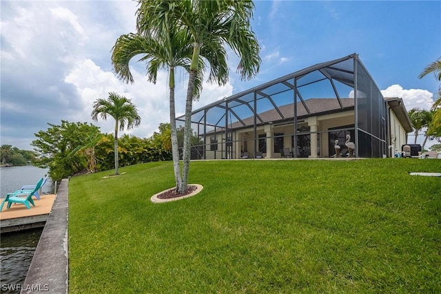 exterior space with a yard, a water view, and glass enclosure