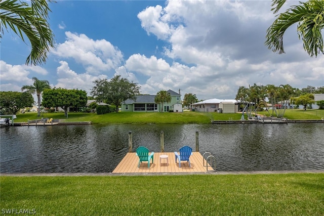 view of dock with a lawn and a water view