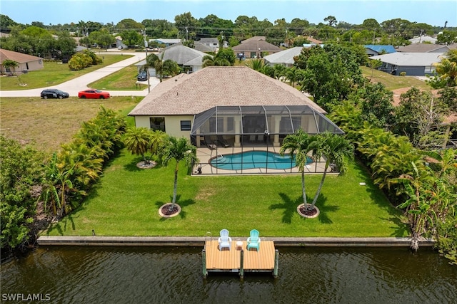 back of property with a water view and a yard