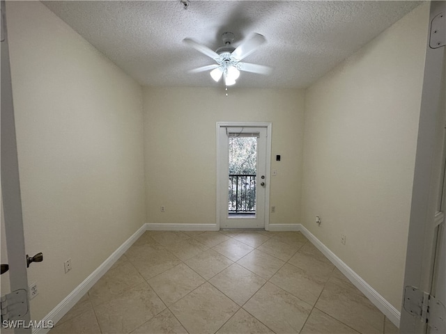 spare room with ceiling fan, a textured ceiling, and light tile patterned floors