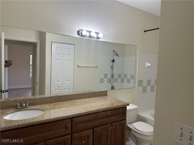 full bathroom with vanity, a textured ceiling, toilet, and tiled shower / bath