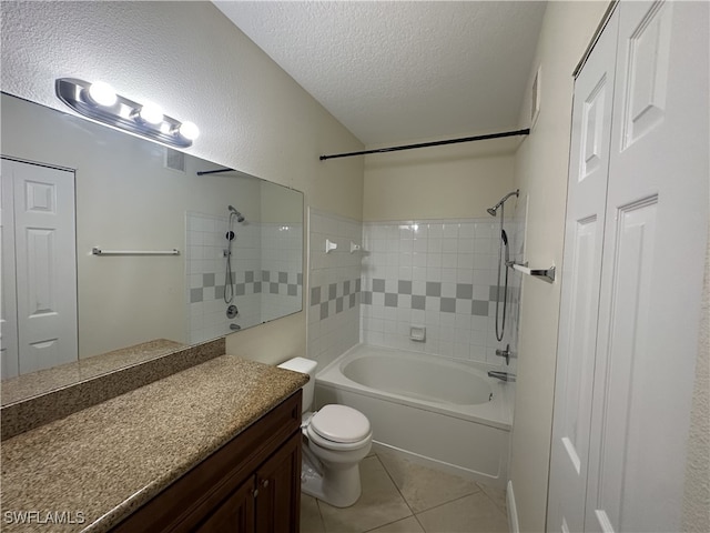 full bathroom featuring a textured ceiling, vanity, tile patterned floors, toilet, and tiled shower / bath combo