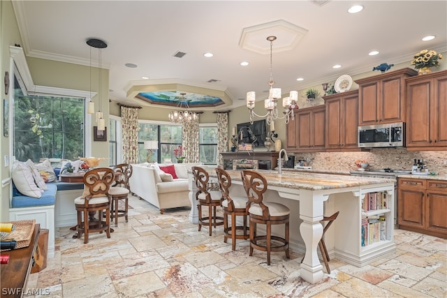 kitchen featuring a notable chandelier, crown molding, tasteful backsplash, and pendant lighting