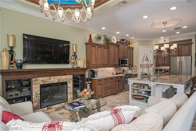 living room featuring a premium fireplace, ornamental molding, and a chandelier