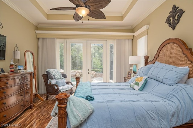 bedroom featuring french doors, wood finished floors, ornamental molding, a raised ceiling, and access to outside