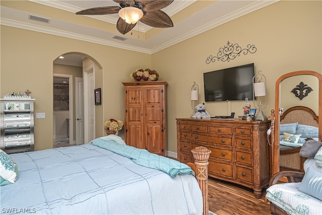 bedroom with wood-type flooring, ornamental molding, and ceiling fan