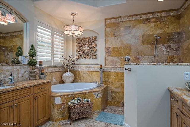 bathroom featuring walk in shower, vanity, a garden tub, and a chandelier