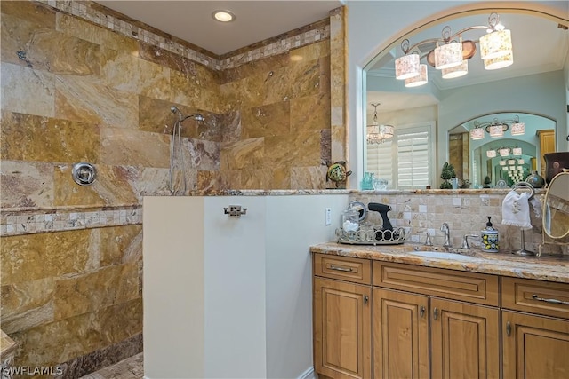 full bathroom with tasteful backsplash, a notable chandelier, vanity, and a walk in shower