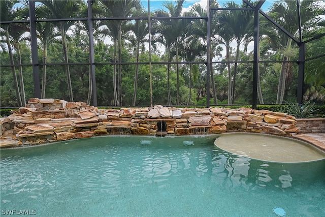 view of swimming pool featuring pool water feature and glass enclosure