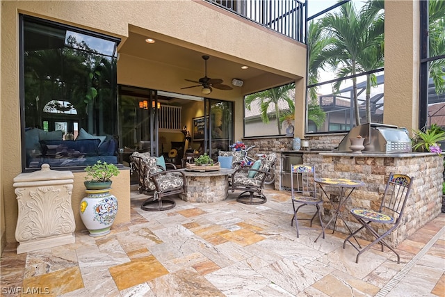 view of patio / terrace featuring ceiling fan, exterior bar, a balcony, and area for grilling