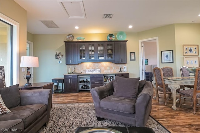 living area with dark wood-style flooring, bar area, visible vents, and recessed lighting