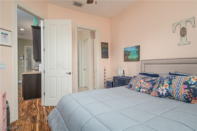 bedroom with baseboards, visible vents, and wood finished floors