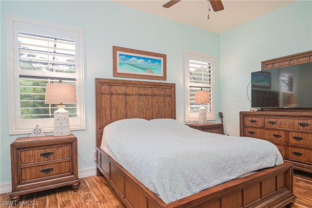 bedroom featuring baseboards, light wood-type flooring, and a ceiling fan