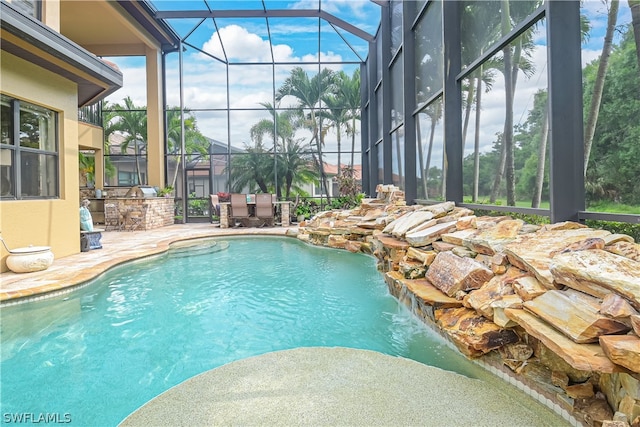 view of pool with a lanai, a patio area, and pool water feature