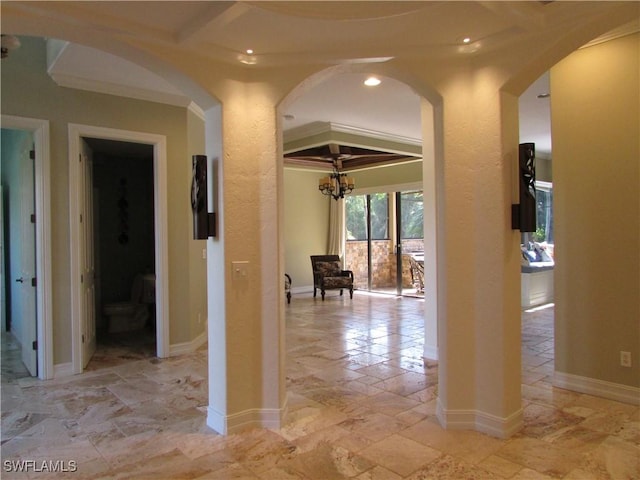 corridor featuring crown molding, arched walkways, a notable chandelier, and recessed lighting