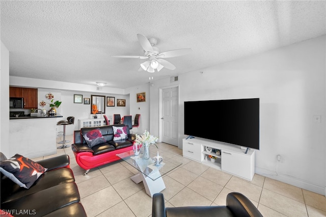 tiled living room with a textured ceiling and ceiling fan