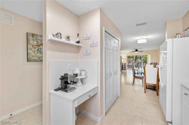 kitchen with white fridge, ceiling fan, light tile flooring, and tasteful backsplash