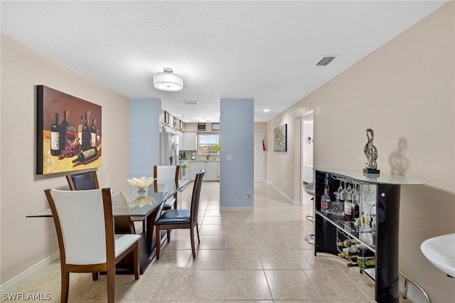 dining room with a textured ceiling and light tile floors