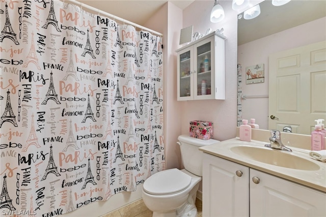 bathroom featuring tile flooring, toilet, and vanity