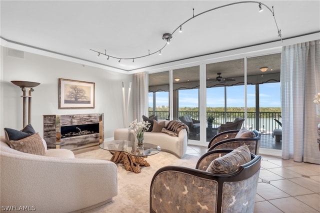 tiled living room with a water view, track lighting, and a wall of windows