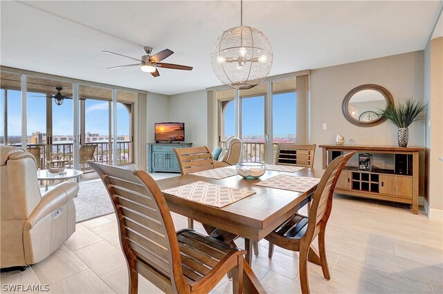 dining area with a wall of windows and ceiling fan