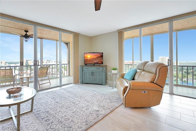 living area featuring expansive windows, ceiling fan, and plenty of natural light
