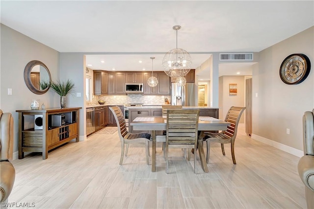 dining area featuring recessed lighting, a notable chandelier, baseboards, and visible vents