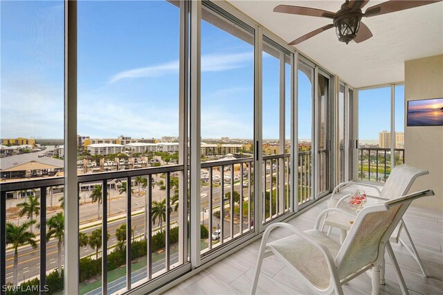 sunroom / solarium featuring a ceiling fan