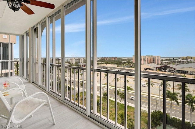 sunroom / solarium featuring a ceiling fan and a view of city