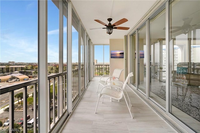 unfurnished sunroom featuring ceiling fan