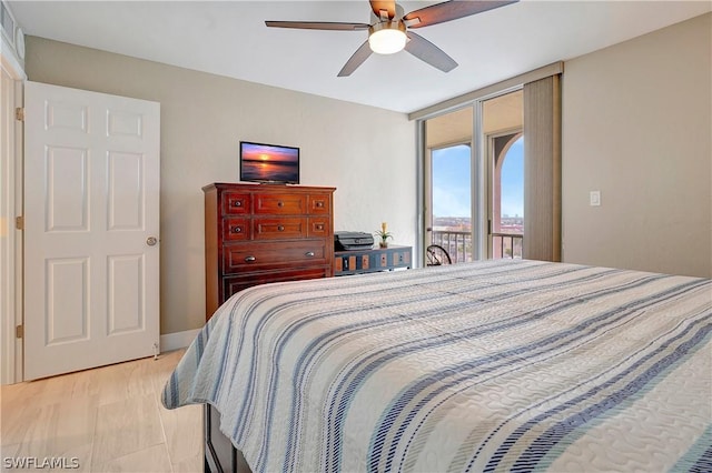 bedroom featuring a ceiling fan, access to exterior, a wall of windows, and light wood-type flooring