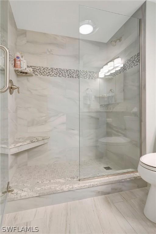 full bath with a shower stall and toilet