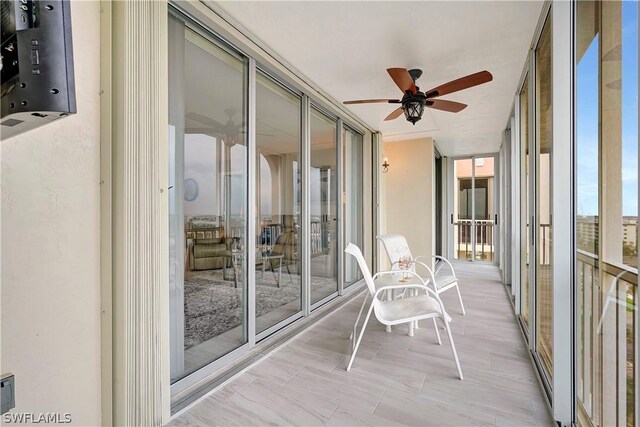 unfurnished sunroom featuring ceiling fan