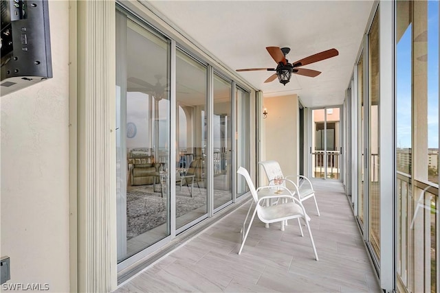 unfurnished sunroom with expansive windows and ceiling fan