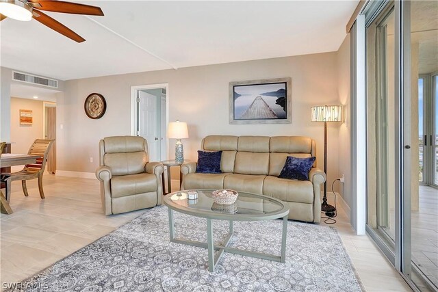 living area with a ceiling fan, visible vents, and baseboards