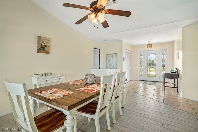 tiled dining space with vaulted ceiling and ceiling fan