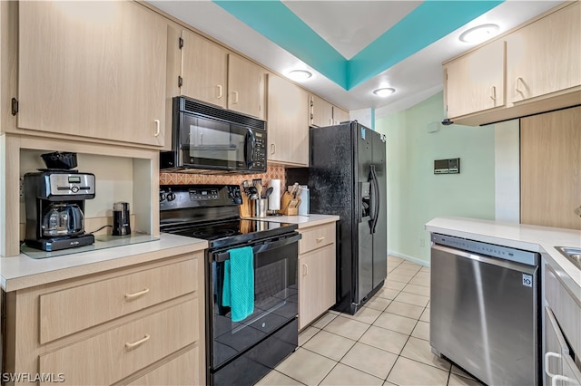 kitchen with light brown cabinetry, light tile flooring, backsplash, and black appliances