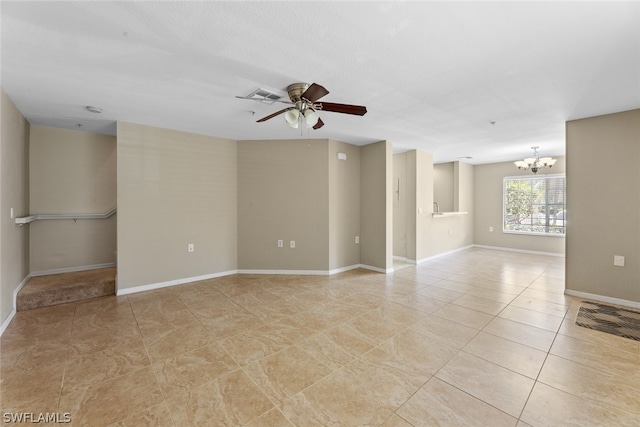 tiled spare room with ceiling fan with notable chandelier