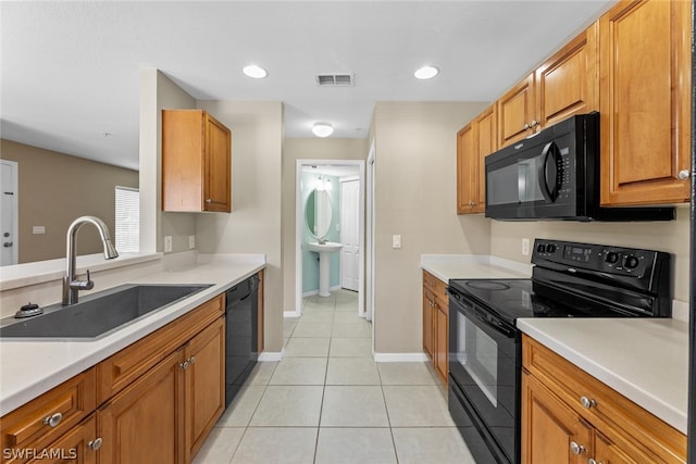 kitchen with sink, black appliances, and light tile patterned flooring